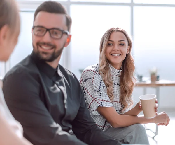 Empleados de la empresa con vasos de café sentados en el vestíbulo de la oficina — Foto de Stock