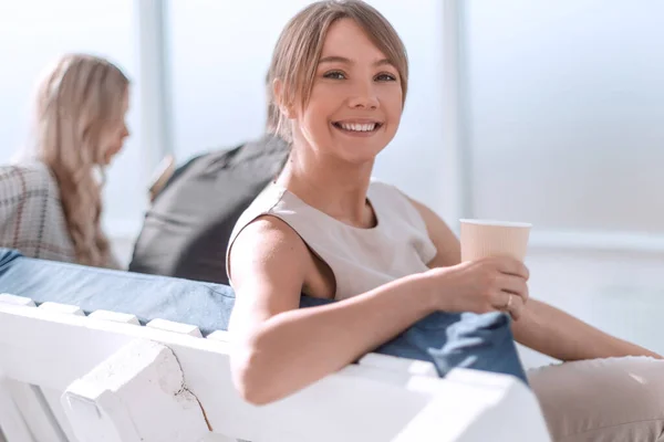 Jovem mulher de negócios com xícara de café sentado no lobby do escritório — Fotografia de Stock