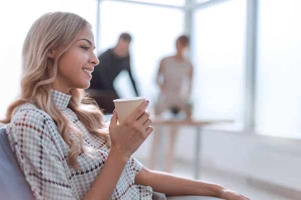 young business woman with a Cup of coffee in a modern office