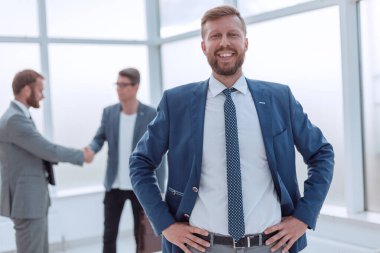 Kapat. Başarılı bir iş adamı parlak bir ofiste duruyor.