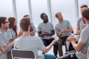 Gençler bir çemberin içinde oturarak bir şeyler tartışıyor..