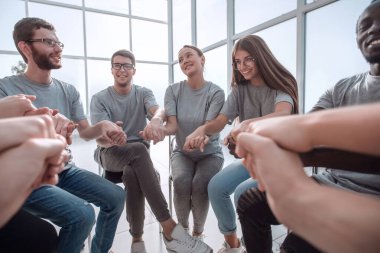 Kapat. Bir grup farklı genç insan el ele tutuşuyor.