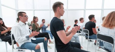 Dikiz aynası. Gençler, gençlik seminerinde alkış tutuyor.