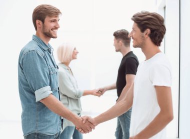 iş arkadaşları ofis lobisinde el sıkışırken.
