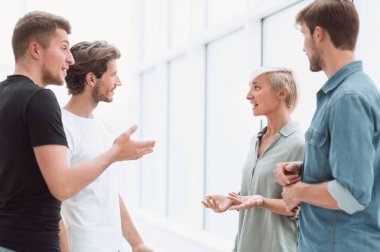 iş arkadaşlarından oluşan bir grup ofis koridorunda bir şey tartışıyorlar