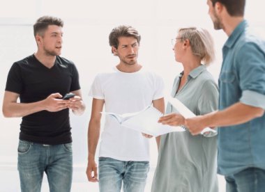 geniş bir ofiste duran eskizlerle bir grup tasarımcı