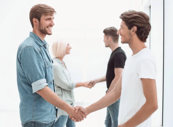 Coworkers shaking hands in the office lobby. — Stock Photo, Image