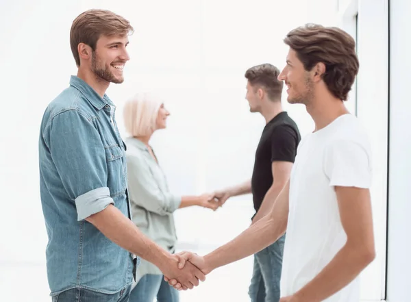 Compañeros de trabajo estrechando la mano en el vestíbulo de la oficina . — Foto de Stock