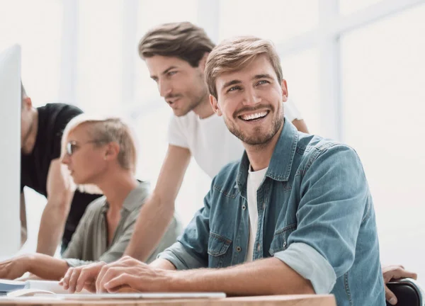 De cerca. sonriente joven sentado en la oficina Escritorio — Foto de Stock