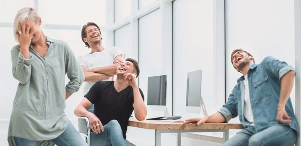 Equipo alegre de jóvenes en el lugar de trabajo . —  Fotos de Stock