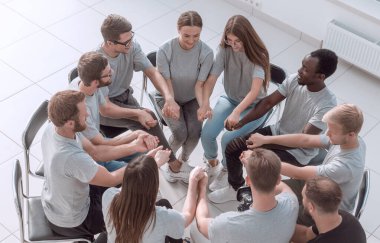 Çemberin içinde oturan bir grup benzer fikirli genç insan..