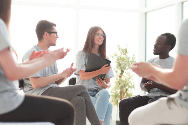 background image. teams of young people sitting in a circle.