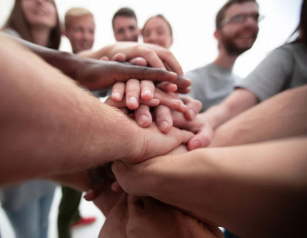 Nahaufnahme. Internationale Gruppe junger Menschen, die ihre Hände zusammenlegen — Stockfoto