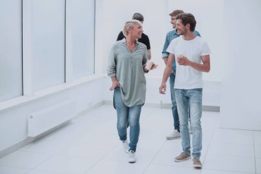 ofis koridorundan geçen kahve bardakları ile çalışanlar