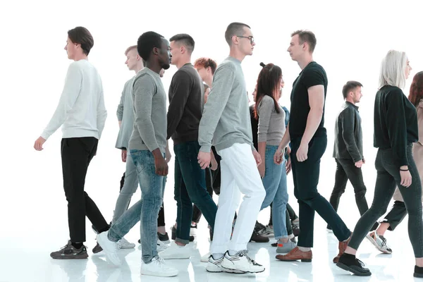 В повному зростанні. різноманітні молоді люди ходять один за одним — стокове фото