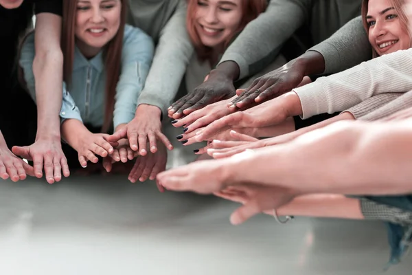 Gruppe lächelnder junger Leute, die sich die Hände reichen — Stockfoto