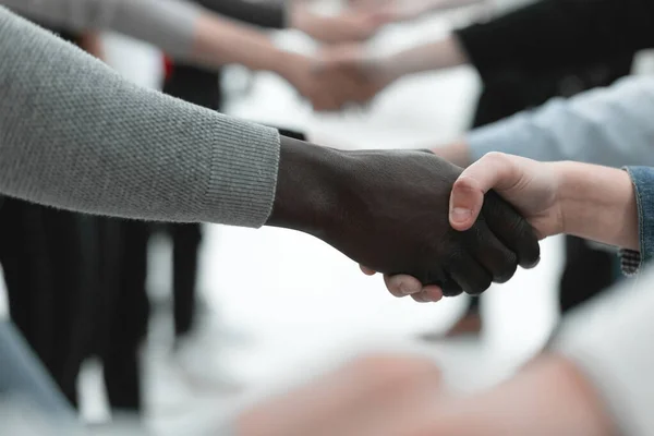 På nära håll. olika ungdomar skakar hand med varandra. — Stockfoto