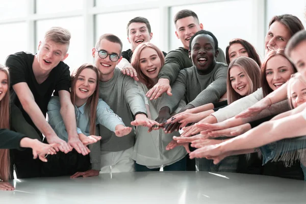 Grupo de jovens sorridentes juntando as mãos — Fotografia de Stock