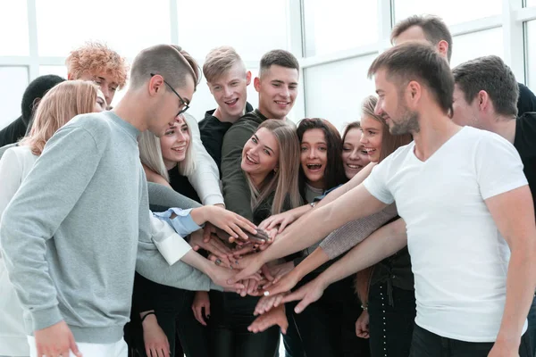 Большая группа молодых людей, объединяющих свои руки. — стоковое фото