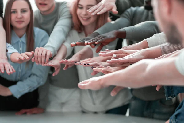 Groep lachende jongeren die hun handen ineenslaan — Stockfoto