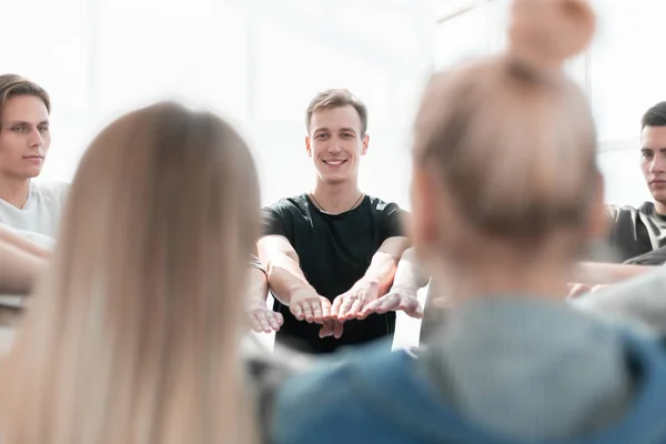 De près. un groupe de jeunes joignant leurs paumes en cercle — Photo