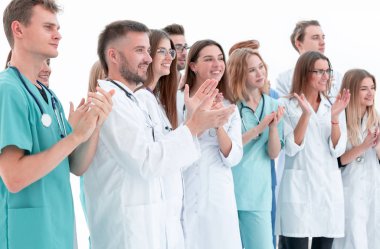 Bir grup stajyer doktor ayakta alkışlıyorlar. başarı kavramı