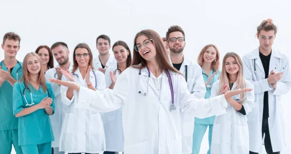 Female doctor standing in front of her applauding colleagues — Stock Photo, Image