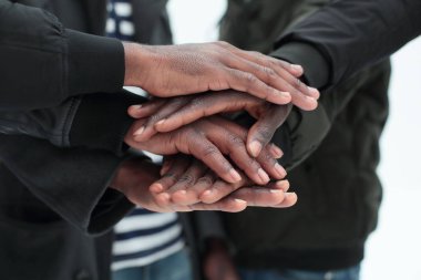 Kapat. Bir grup arkadaş ellerini birleştiriyor.