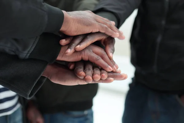 Fecha. um grupo de amigos colocando as mãos juntas — Fotografia de Stock