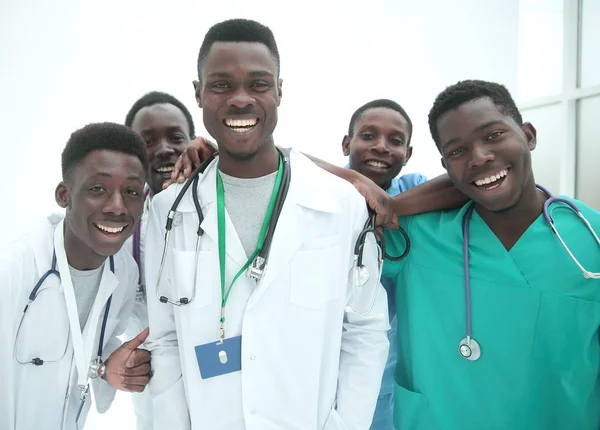 W pełnym wzroście. uśmiechnięci młodzi lekarze stojący jeden po drugim — Zdjęcie stockowe