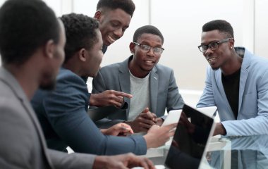 bir grup çalışan dijital tabletin ekranına bakıyor.