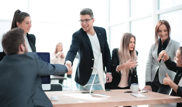 business people shake hands over an office Desk.