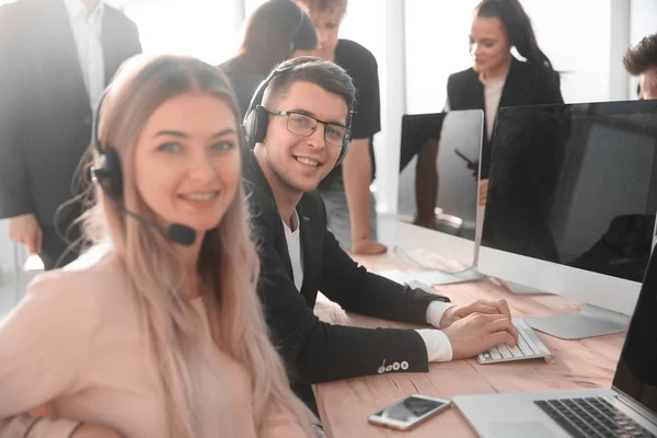 Jovem consultor call center sentado em sua mesa — Fotografia de Stock