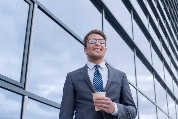 Gelukkige jonge zakenman staan in de buurt van hoog kantoor gebouw — Stockfoto