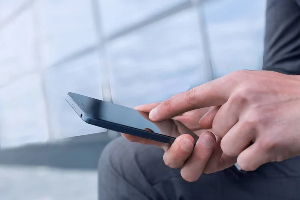 På nära håll. affärsman väljer kontakt på sin smartphone. — Stockfoto