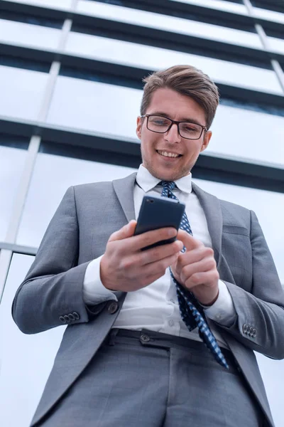 Χαμογελαστός επιχειρηματίας διαβάζει sms στο smartphone του — Φωτογραφία Αρχείου