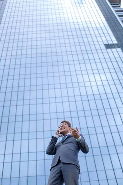 Glad affärsman med smartphone står framför höghus kontorsbyggnad — Stockfoto