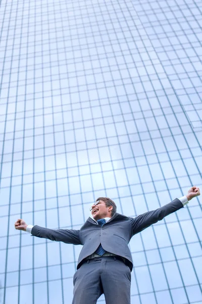 Heureux jeune homme d'affaires debout dans la rue devant le bureau — Photo