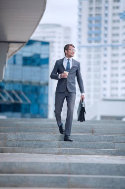 Büyük bir şehrin caddesinde yürüyen bir iş adamı.