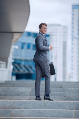 Gülümseyen iş adamı iş merkezine doğru tırmanıyor.