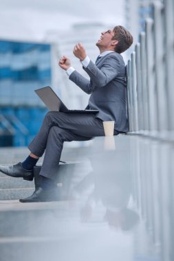 Modern aletleri olan genç işadamı jest yapıyor.