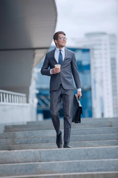 Homem de negócios andando pela rua de uma cidade grande — Fotografia de Stock