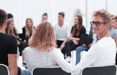 Kapat. Çemberin içinde oturan bir grup genç..