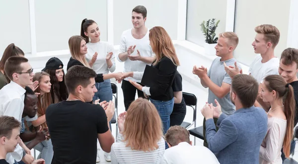 Jóvenes estrechando las manos en un círculo de personas de ideas afines —  Fotos de Stock