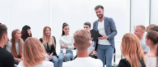 Entrenador de negocios de pie en un círculo de jóvenes. —  Fotos de Stock