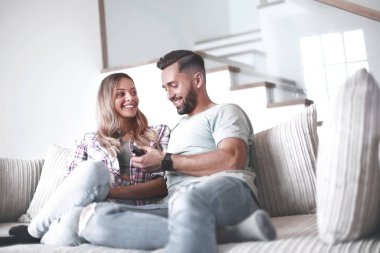 Sıcak oturma odasındaki kanepede oturan sevgili çift.