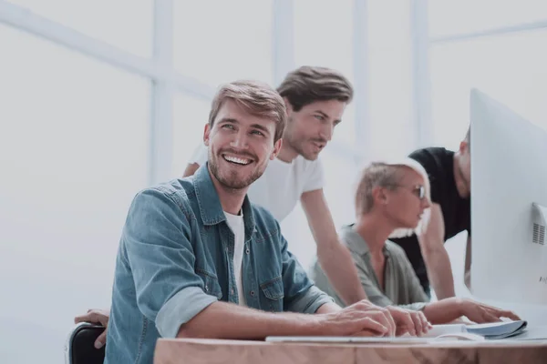 De près. jeune homme souriant assis au bureau Bureau — Photo