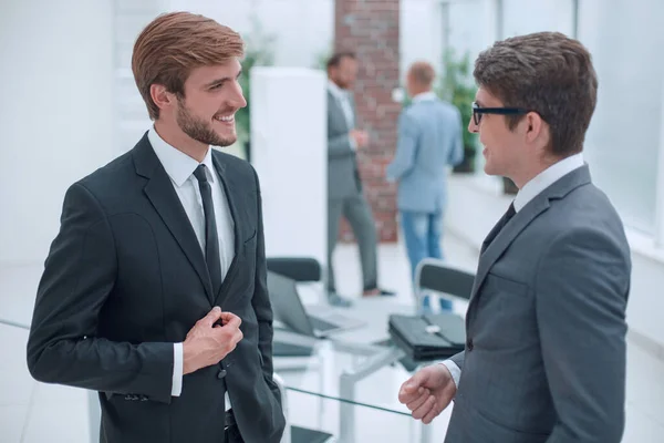 Два молодих підприємці розмовляють стоячи в офісі . — стокове фото
