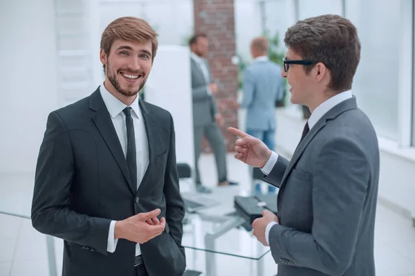 Empleados discuten sus ideas de pie en la oficina . — Foto de Stock