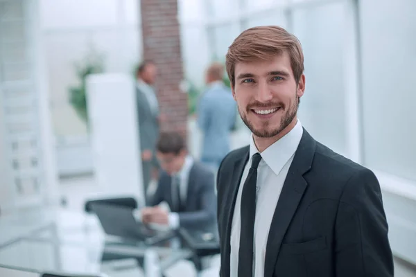 På nära håll. leende affärsman stående på sitt kontor. — Stockfoto